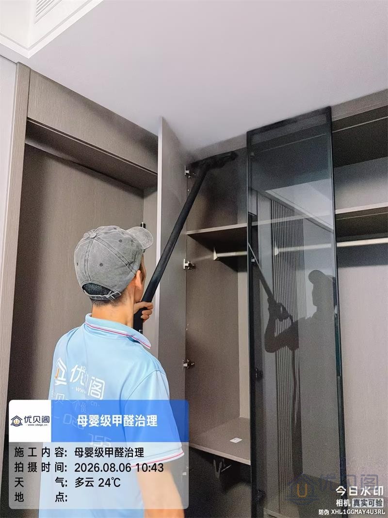 施工人员穿戴防护装备,对紫檀府新房客厅墙面进行除醛作业